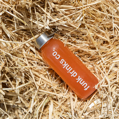 Funk Drinks Co Strawberry Lemonade cold pressed juice bottle lying on straw
