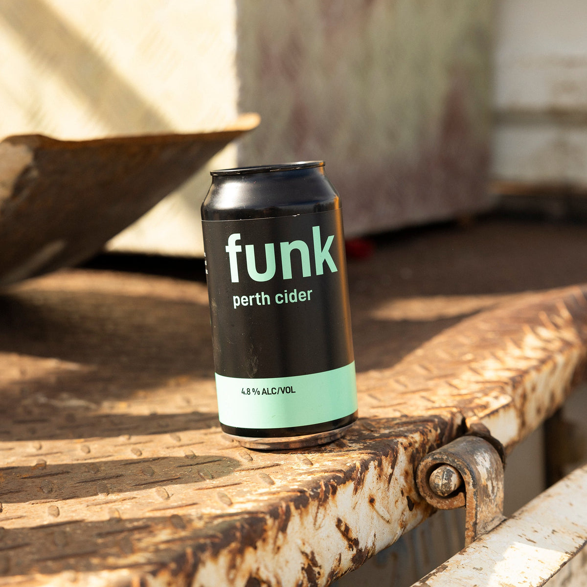 Can of Funk Perth Cider on a rusted metal step in afternoon sun