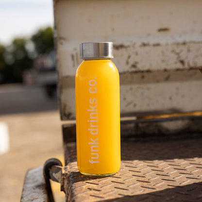 Funk Drinks Co Tropical cold pressed juice bottle on a weathered farm ute tray