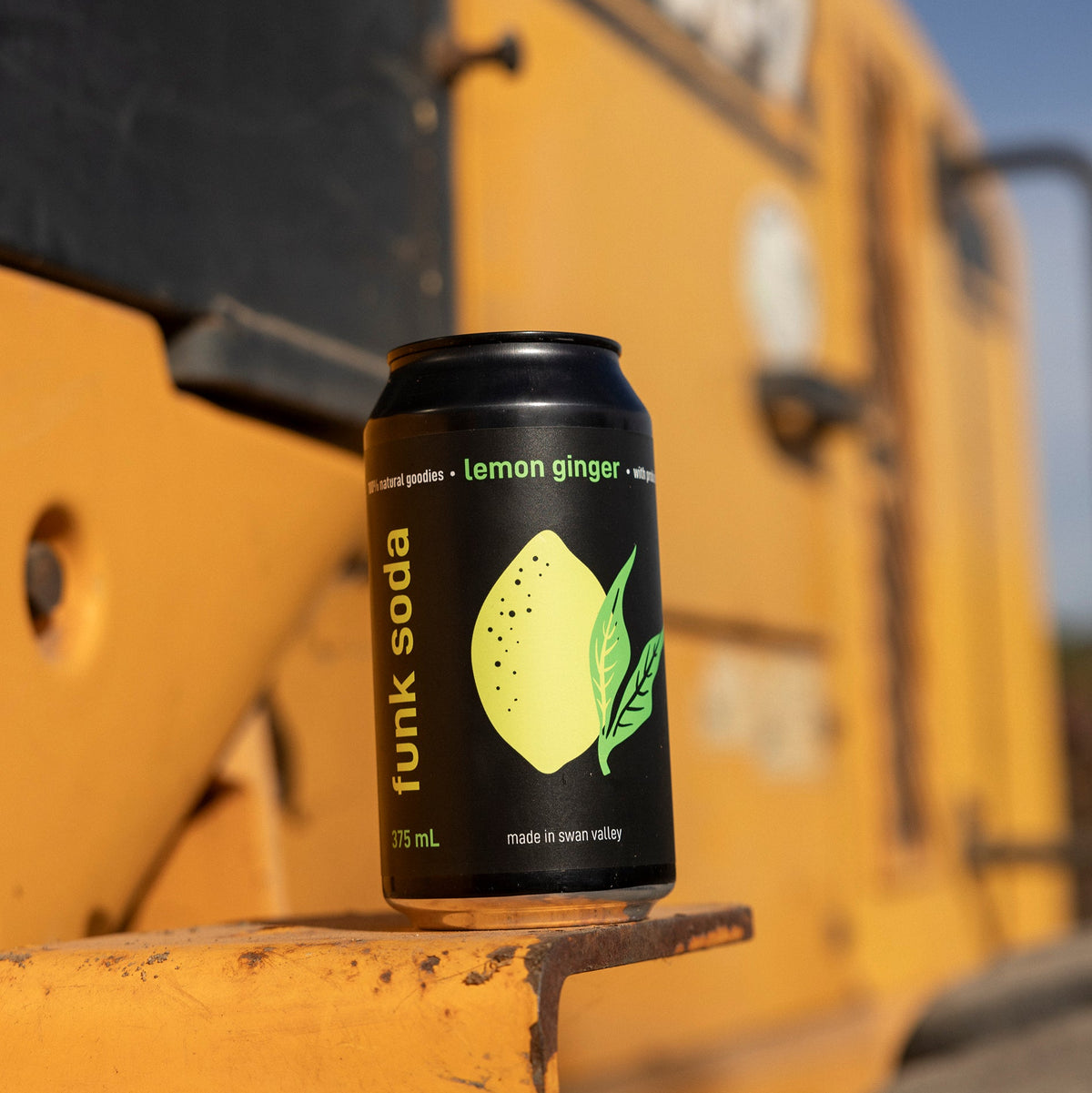 Can of Funk Lemon Ginger craft soda sitting on the step of a yellow tractor