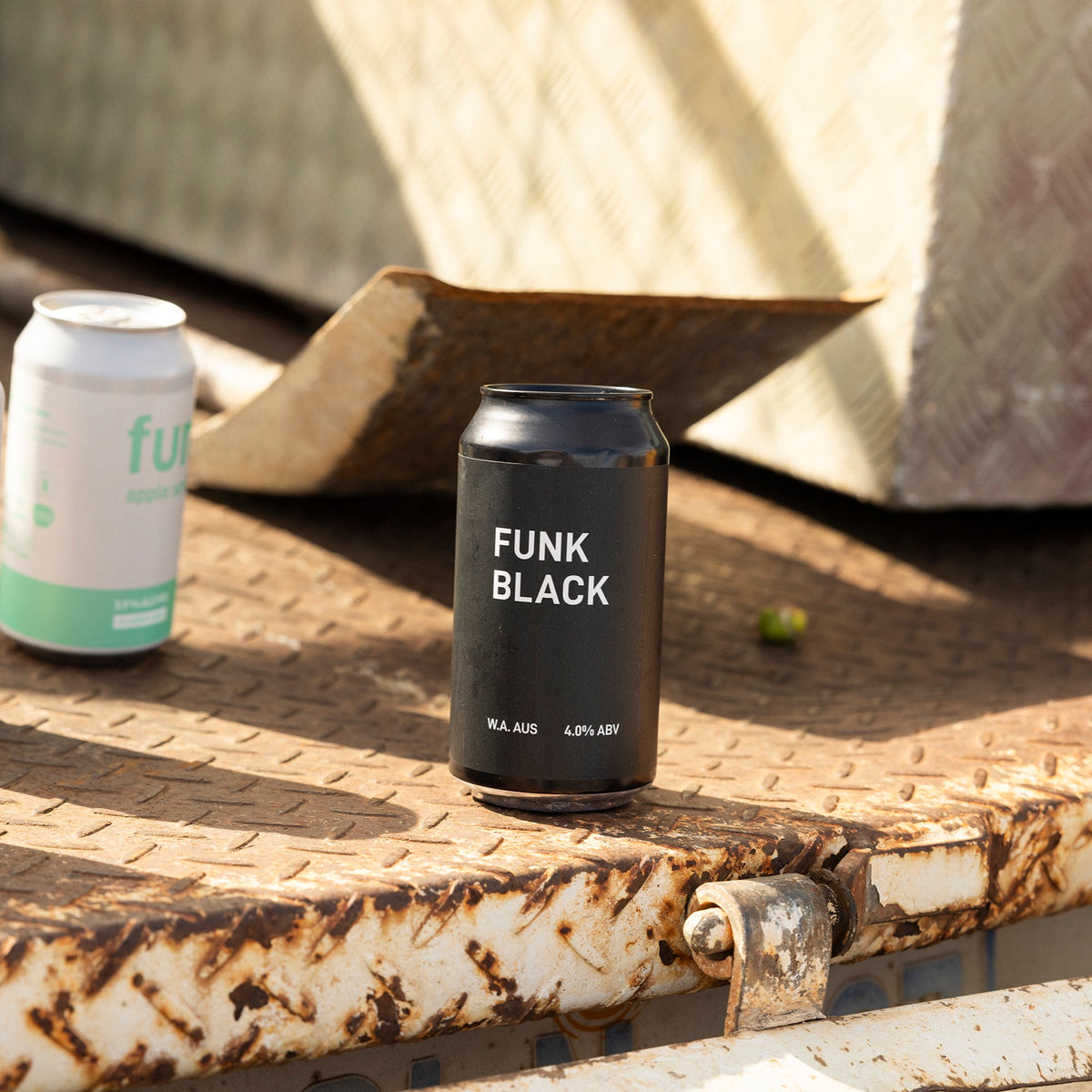 A can of Funk Black on a weathered ute tray with the rest of the Funk range behind