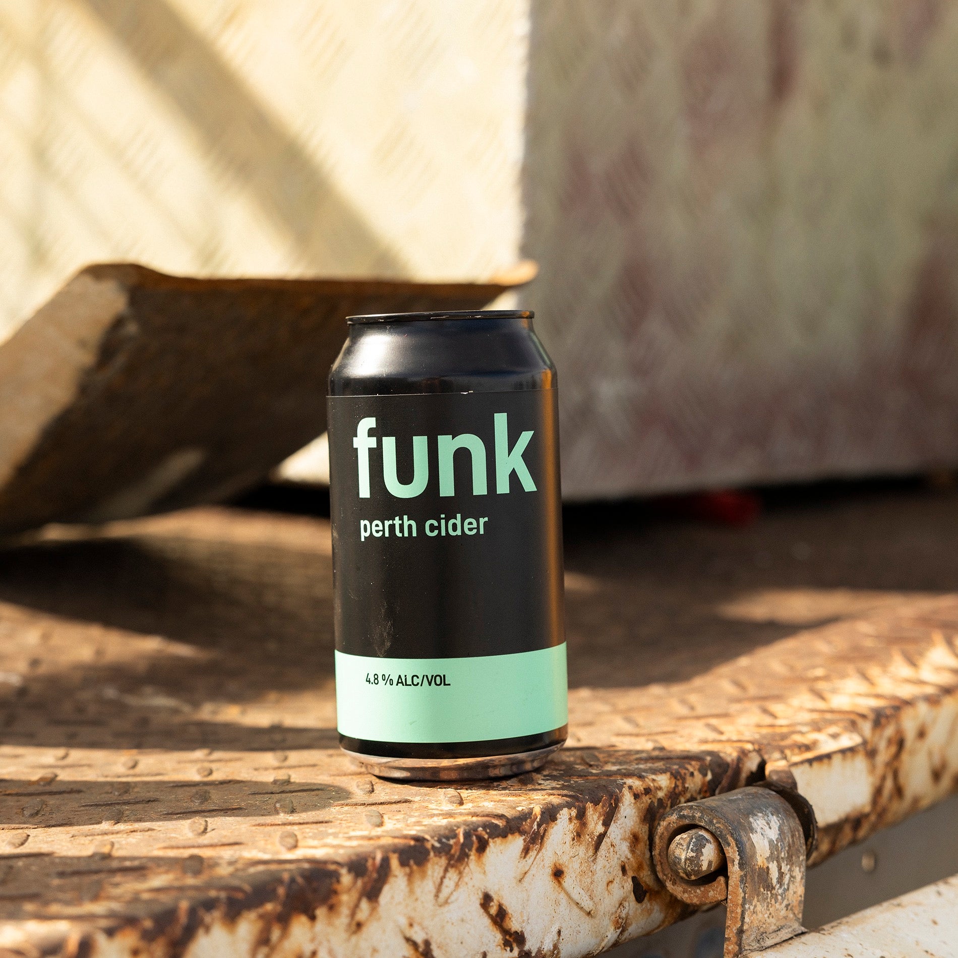 A can of Funk Perth Cider on a rusted farm trailer in afternoon sun